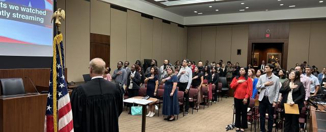 Naturalized citizens singing the national anthem in the courtroom