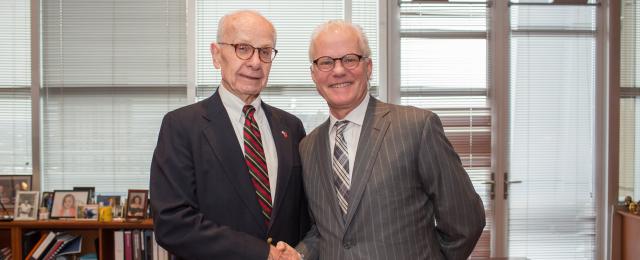 U.S. District Judge David Doty shaking hands with newle sworn in U.S. Magistrate Judge Steven Rau.
