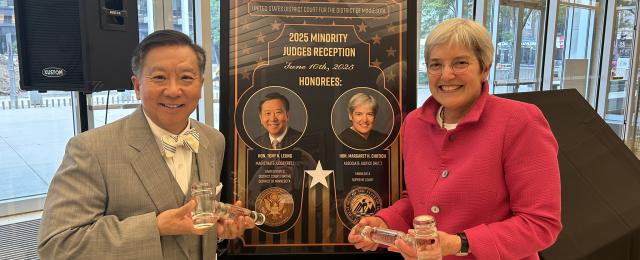 Retired Magistrate Judge Tony Leung and Retired Minnesota Associate Supreme Court Justice Margaret Chutich holding glass gavels in front of their commemorative poster at the Minority Judges Reception.