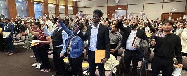 Group of newly naturalized citizens waving flags in the Minneapolis courthouse
