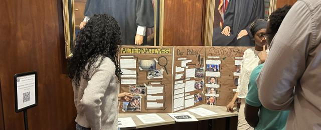 Students standing in front of an advocacy board.